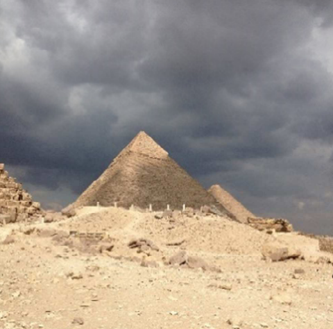 Pyramiden in der Wüste unter dunklem, bewölktem Himmel